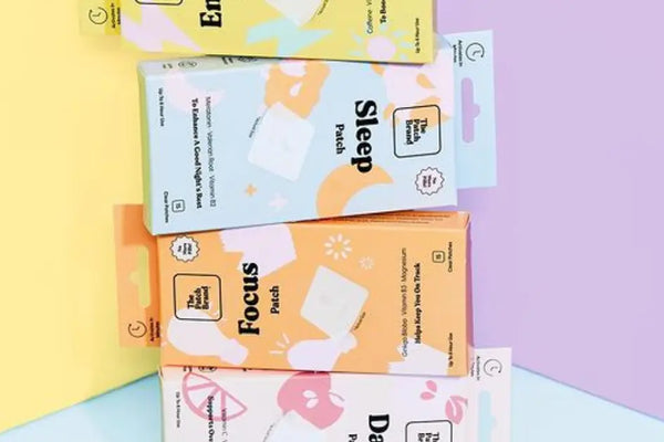 Vitamin patch packs labeled Energy, Sleep, Focus, and Day displayed on a pastel-colored background